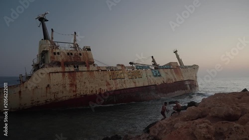 Rusty old shipwreck near the coastline on sunset