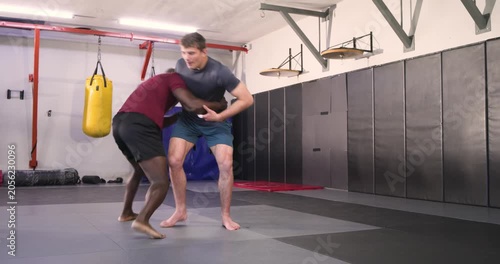 Clinching at gym, african american athlete driving for takedown securing backlock