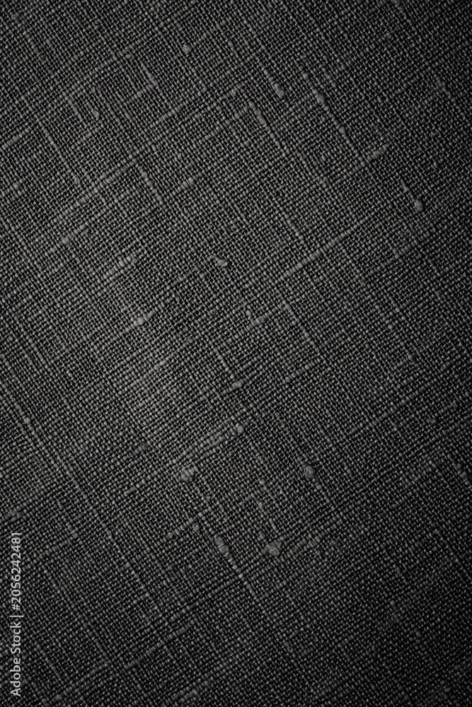 Fototapeta premium Black textured surface with fabric-like pattern shown in a close-up view under even lighting