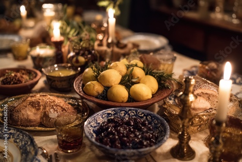 Large family table with whole preserved lemon and olive assortment as centerpiece with fresh bread, North African family staple tradition