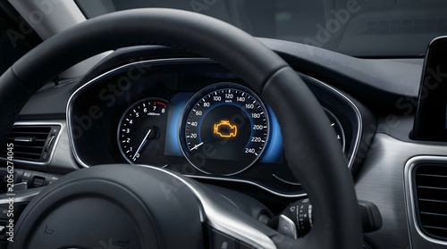 Close view of a car dashboard with a check engine warning light on the instrument cluster, useful for automotive service, vehicle maintenance, and repair content