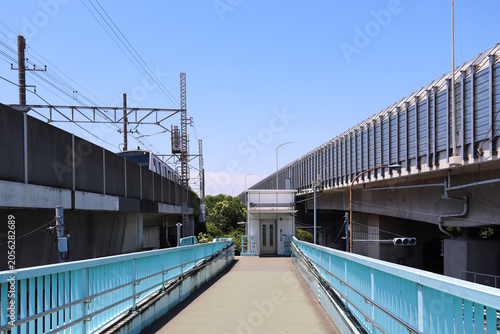 Fotografie 線路と高速道路に挟まれた歩道橋とエレベーターの風景