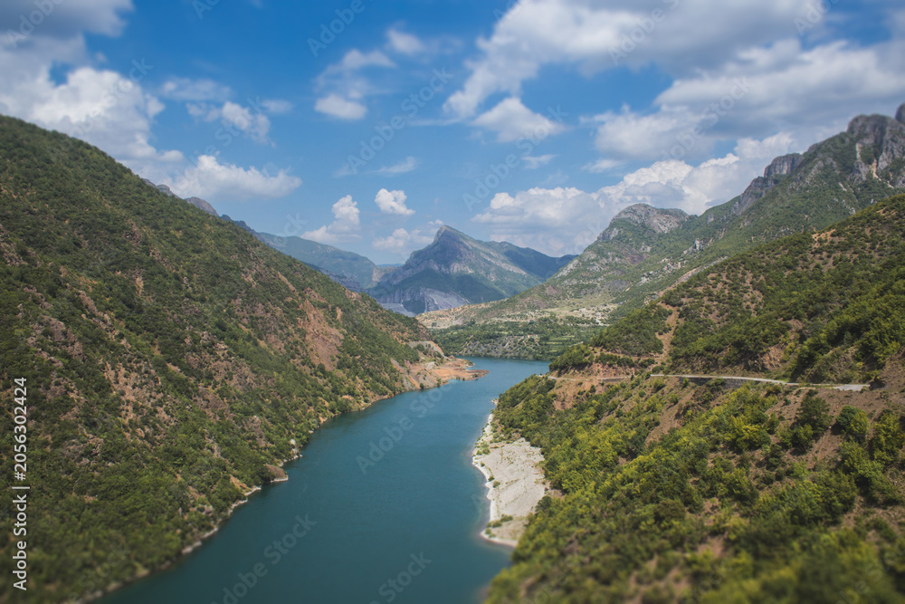 Fototapeta premium Scenic view of the turquoise Lake Koman winding through the rugged mountains of Albania