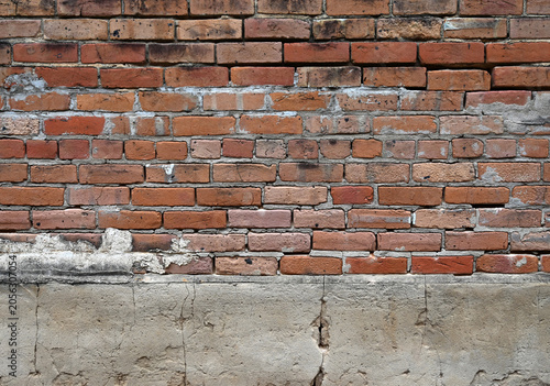 Foto Horizontal close up of a deteriorating red brick and concrete wall with cracked