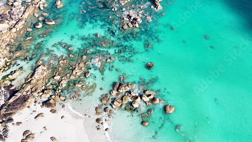 Spektakuläre Luftaufnahme vom Plage de Boutrouilles: Imposante, helle Granitfelsen liegen eingebettet im glasklaren, leuchtend türkisfarbenen Wasser des Atlantiks.