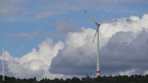 Windrad vor großen Quellwolken