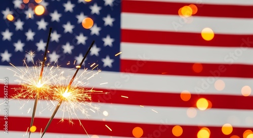 Sparklers in front of american flag with bokeh lights on 4th of july celebration