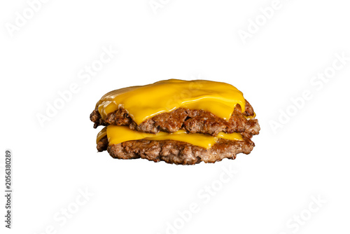 Close up of two juicy beef burger patties stacked with melted cheddar cheese, isolated on white background
