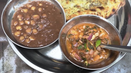 Traditional Punjabi meal featuring spicy chole, flaky laccha paratha and onion chutney.