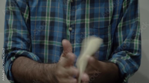 Hands kneading dough for making flaky laccha paratha during food preparation.