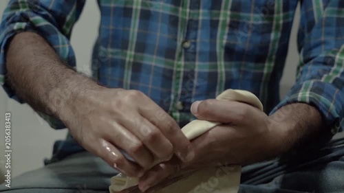 Hands kneading dough for making flaky laccha paratha during food preparation.