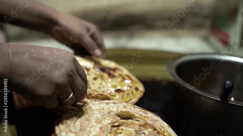 Close up shot of butter being applied on freshly cooked tandoori roti.