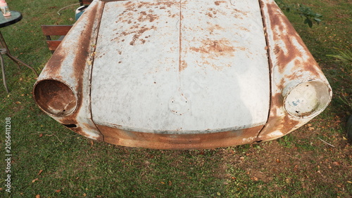 Front View of an Abandoned Rusty Vintage Sports Car in a Garden
