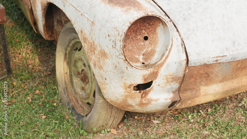 Close-up of a Rusted Car Front with Overgrown Grass