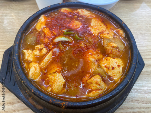 korean spicy tofu stew in black earthenware bowl top down view