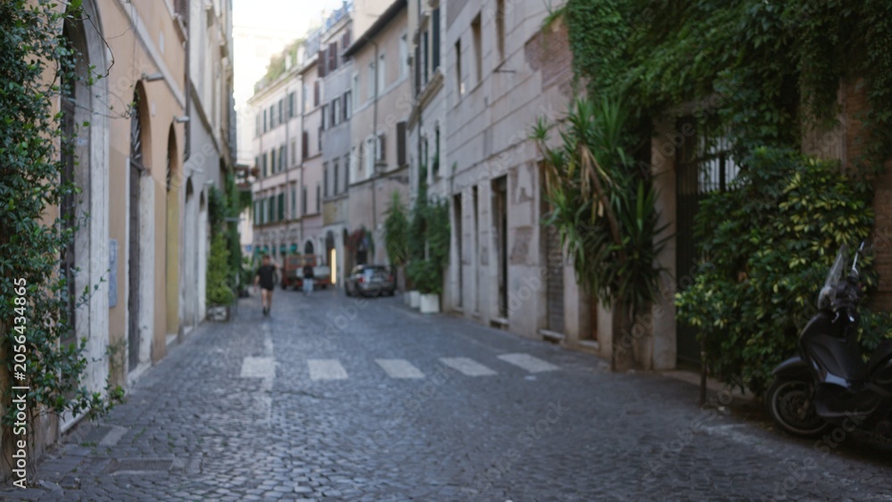 Fototapeta premium Narrow cobblestone lane seen defocused with soft bokeh and shallow focus, street; background copyspace backplate calm.