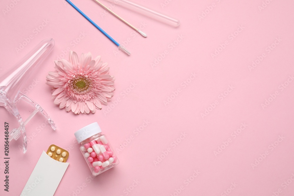 Naklejka premium Flat lay composition with gynecological examination kit and gerbera flower on pink background, space for text