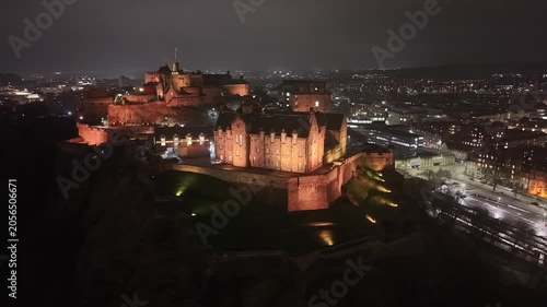 Aerial view of the Edinburgh Castle on Castle Rock at night with the illuminated city on the background Scotland, United Kingdom