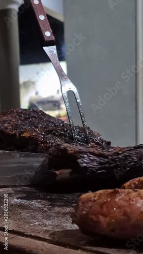 Close Up of Grilled Beef Being Sliced on Wooden Board
