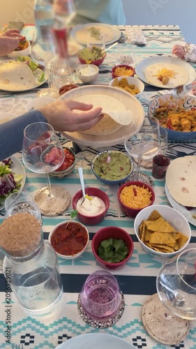 Mexican fajitas dinner table with tortillas, salsas, and various side dishes arranged for a meal