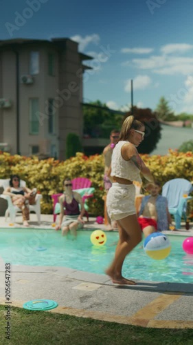 Friends relax by the pool as a woman playfully splashes water at them. They are enjoying a fun and refreshing summer day outdoors.