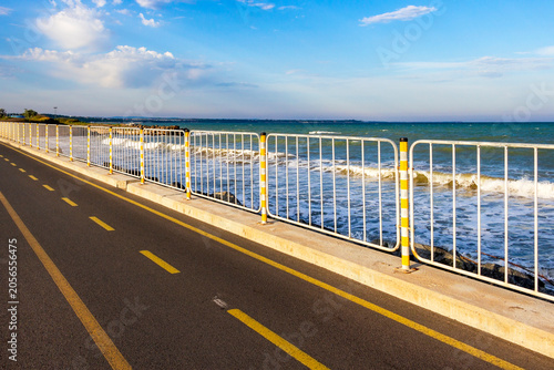 The coastal and bike path between the salt pans of Burgas and Sarafovo on a sunny May day, view of the waters of the Black Sea behind the railing