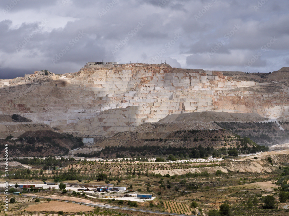 Fototapeta premium Marble quarry exposed to rays of sunlight on a cloudy day in Alguena, Spain