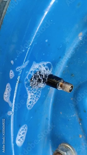Checking the wheel with a soap solution, Finding an air leak in the tire with soap suds around the nipple