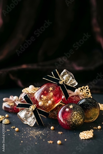 Luxury Red and Black Resin Candy Charms with Gold Glitter and Pearls on Dark Background