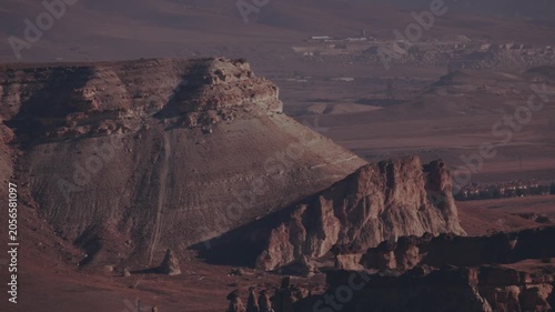 Cappadocia landscape shows rock formations and distant towns in daytime