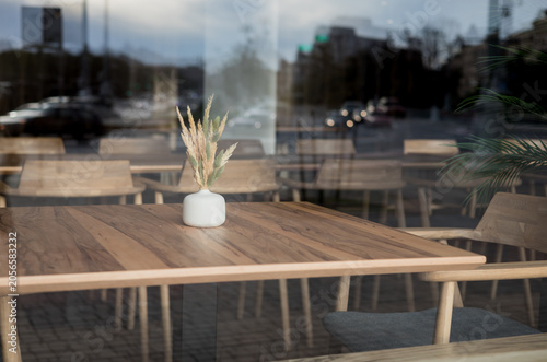 Obraz na płótnie Empty cafe table with vase view through window glass.