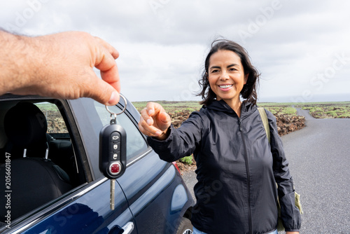 Konstfotografi Woman receiving car keys from hand, symbolizing vehicle rental, shared mobility,