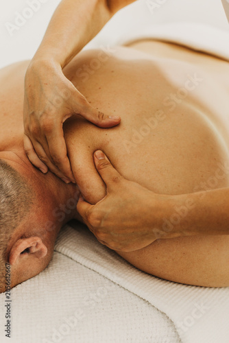 Close up of neck massage therapy session. Female massage therapist's hands.