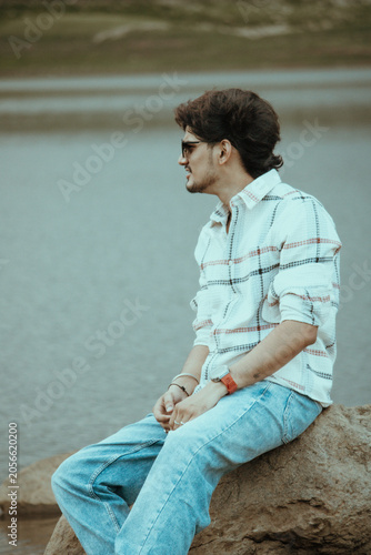 young man sitting on the rock