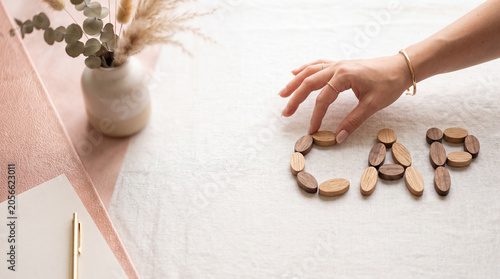 Financial capital and venture market concept with small oval wooden pieces spelling CAP on a linen tablecloth with negative copy space and hand touch