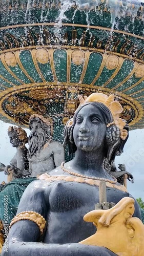 Ornate bronze sea god sculptures decorate baroque fountain in central Paris square
