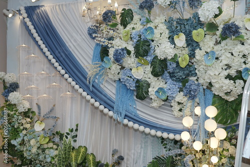 Sophisticated event decoration with white and blue flowers and drapes, creating a beautiful, serene, and memorable celebration backdrop