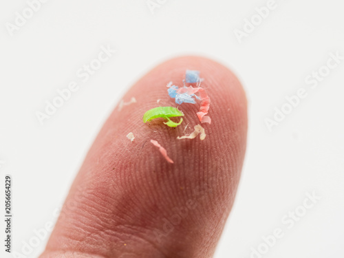 Trozos de microplásticos sobre un dedo de la mano