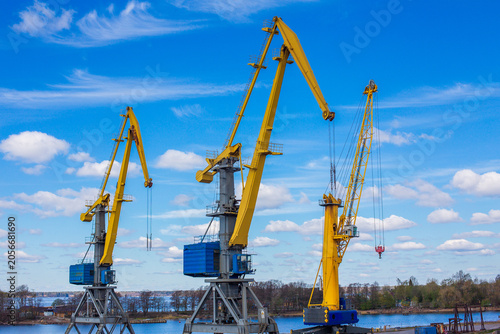 Yellow Industrial Harbor Cranes on River Pier with Blue Sky and Cumulus Clouds Saint Petersburg Russia