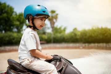 3 Year Old Boy in Blue Helmet Riding Horse on Track