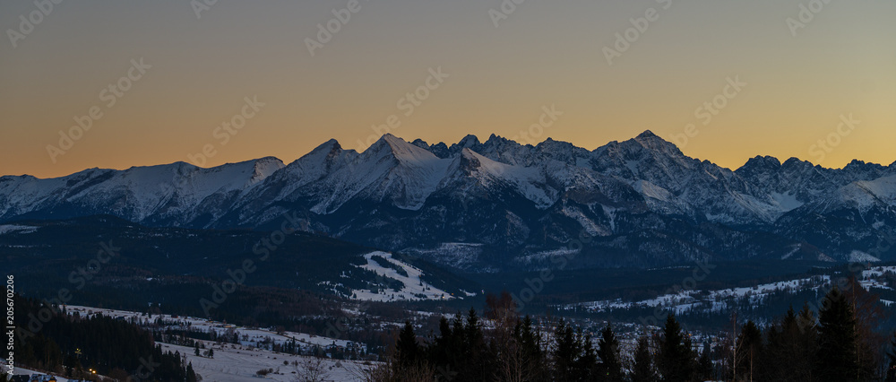 Fototapeta premium Majestic Tatra mountains landscape covered with snow in winter. Panoramic view of snowy rocky peaks against blue sky