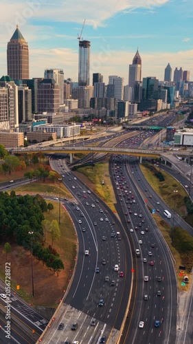 Aerial view of downtown Atlanta city landscape with skyscraper buildings and flowing highway traffic, highlighting urban growth, transportation infrastructure and modern American metropolis.