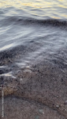 Close Up of Water Rippling on Sandy Shore