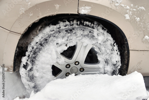 Car tires in deep snow. A challenging road and transportation concept.