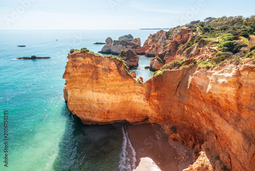 Foto Les falaises rouges et l'eau turquoise de la plage Praia Joao de Arens près de P