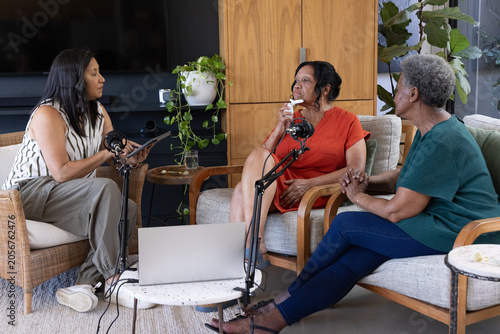 African American women hosting and recording conversation in home studio with boom mics and laptop