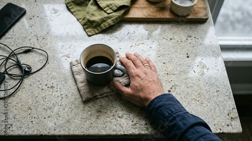 Man's Hand Resting by Morning Coffee on Kitchen Counter, Relaxing Routine