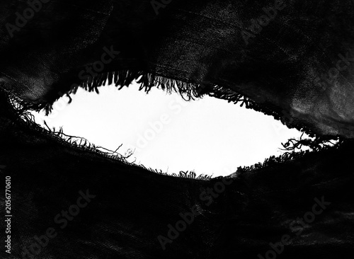 Grunge beige canvas denim fabric torn circle round rounded oval frame. Texture abstract background backdrop cotton fabric with black crumpled torn rectangle frame. Texture abstract background.