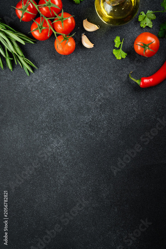 Fresh tomatoes, basil, rosemary, spices and pepper on black table. Flat lay image with space for design.