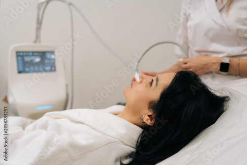 Canvas Print Side view of professional cosmetologist performing microneedle rf face lifting treatment on middle-aged woman cheek for skin tightening, rejuvenation, antiaging care in beauty clinic